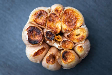 Garlic clove grilled on black stone background; top view.の写真素材