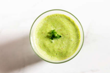 Healthy green kale smoothie with greek yogurt in a glass isolated on white table background, top view. Kale is considered a superfood because it's a great source of vitamins and minerals.の写真素材