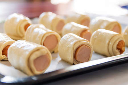 Mini sausage wrapped in puff pastry in oven tray prepare for bake.の写真素材