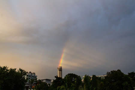 Dramatic scenery of rainbow over a top of the building in the evening after rain.の写真素材