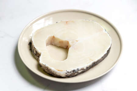 Snow fish on plate for delicious good meal. Snow fish are found in the deep ocean, thick flake and melt-in-your-mouth texture. Isolated on white marble table background.の写真素材