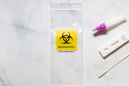 Covid-19 Rapid Antigen Test kit and biohazard specimen bag on white background. Concept of waste...