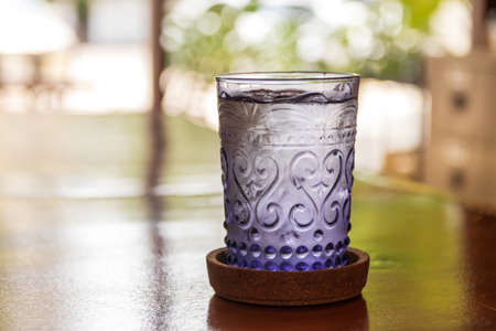 A glass of water on a wooden table in a cafe or restaurantの写真素材