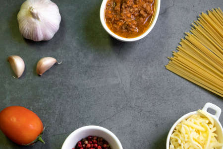 Italian food ingredients for spaghetti bolognese. Raw spaghetti pasta with various ingredient on...