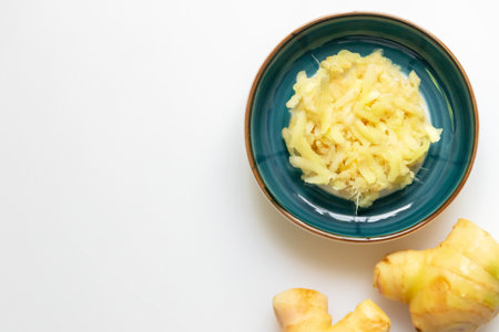 Ginger grate with a handheld grater. Top view isolated on white background and copy space.の写真素材