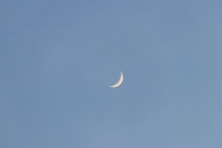 Crescent moon on blue sky. Look like a smile on a good day.の写真素材