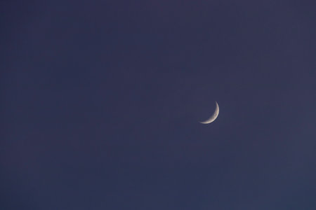 Crescent moon on blue sky. Look like a smile on a good day.の写真素材