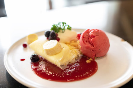Soft crape with sorbet ice cream with berry juicy sauce and banana sliced with crumble.の写真素材