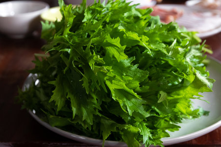 Mizuna or Kyona (Japanese water vegetable) on table with meat and soup for delicious shabu shabu.の写真素材