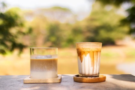 Latte and dirty coffee on table in the garden with shade of sunlight. Good time with coffee.の写真素材