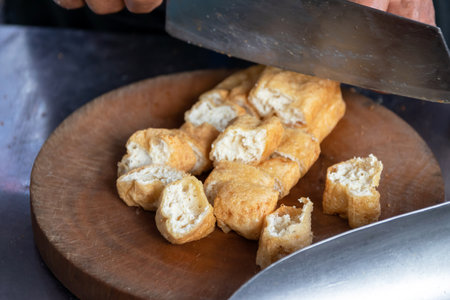 Deep fried tofu on chopping board usually serving with peanut sweet and sour dipping sauce.の写真素材