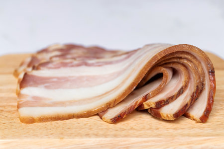Smoked bacon sliced on wooden board.