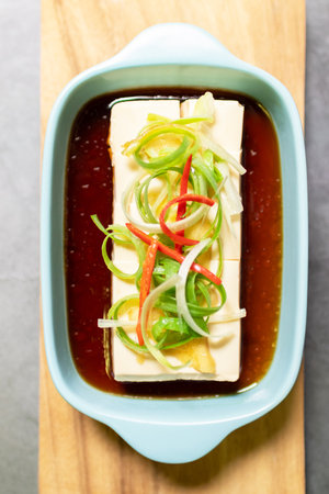 Vegan silken tofu is served hot or cold with a savory soy sauce flavored with sesame oil, ginger and green onions .の写真素材