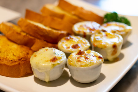 Baked baby clams with butter, onions, parsley served with garlic and butter french bread.の写真素材