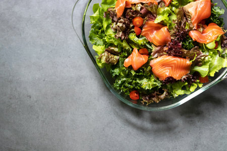 Fresh salmon with healthy green salad kale and tomato on glass bowl.の写真素材