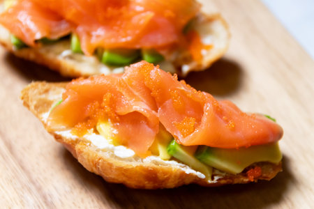 Smoked salmon with cream cheese and avocado slide on fresh croissants.の写真素材