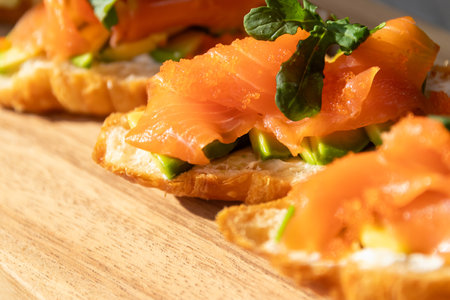 Smoked salmon with cream cheese and avocado slide on fresh croissants.の写真素材