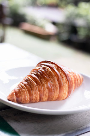 French croissant on plate on vintage wooden table background.の写真素材