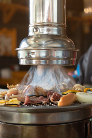 Grilled meat and vegetables being grilled on barbecue grill in a restaurant.の写真素材
