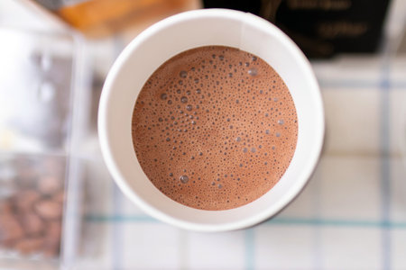 Hot chocolate or cocoa drink in paper take away cup, top view.