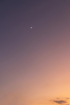 Crescent moon in the blue sky at sunset. Natural background.の写真素材