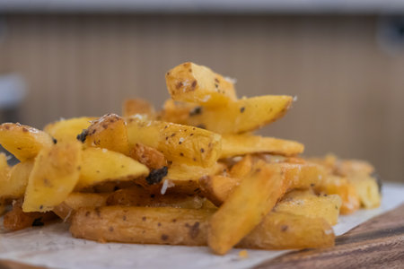 Rustic homemade baked potato wedges seasoned with herbs and spices.の写真素材