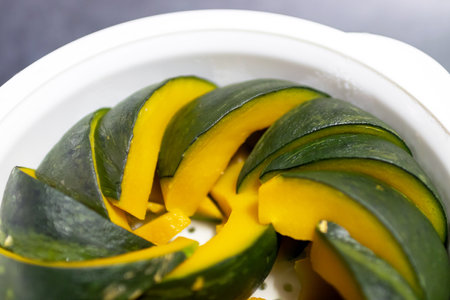 The pumpkin is placed in a streamer for microwave. The pumpkin is then steamed until it is soft. Easy and healthy menu.の写真素材