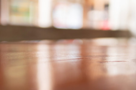 A close-up view of polished wood flooring, highlighting its smooth texture and warm tones in a softly blurred interior.の写真素材