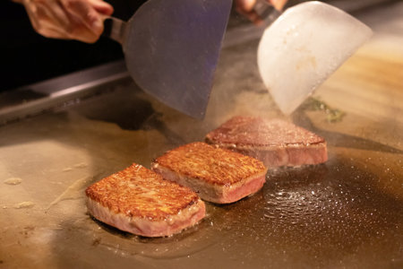 Grilled meat sizzling on a hot plate.の写真素材