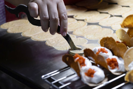 A hand crafting traditional snacks. Khanom Beaung or a kind of filled pancake Thai dessert; Thai Style Crisp Tart.の写真素材