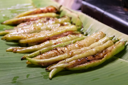 Grilled green chili peppers on a banana leafの写真素材