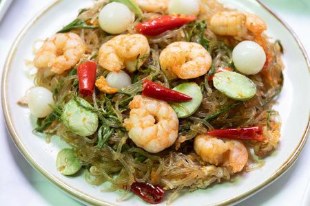 Stir-fried shrimp noodles asian cuisine dish indoor setting close-up view flavorful experience.の写真素材