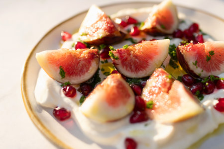 Delicious fig healthy garnished with pomegranate on yogurt and olive oil.の写真素材