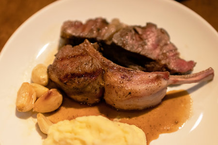 Grilled lamb ribs with mashed potato and grilled garlic.の写真素材