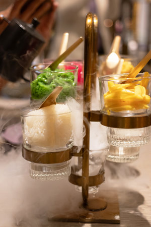 Colorful desserts served in elegant glasses with a smoky effect and vibrant toppings.