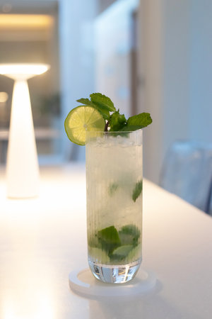 Mojito with soft light in cozy moment, fresh lime juice is added to sugar (or to simple syrup) and mint leaves. The mixture is then gently mashed with a muddler.の写真素材