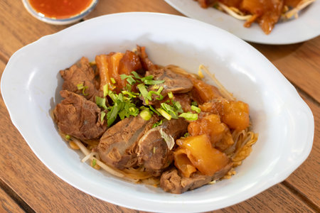 Delicious bowl of tender meat and vegetables served with a flavorful sauce, embodying comfort food at its finest.の写真素材