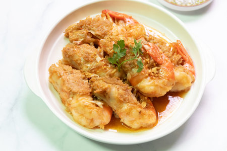 Deliciously fried shrimp served on a white plate, garnished with herbs and complemented by a flavorful sauce.の写真素材