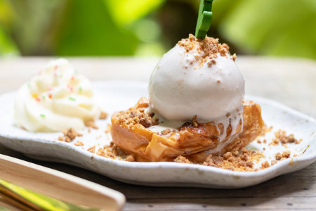 Delicious dessert featuring pastry with ice cream, topped with crumbs and served with whipped cream. Perfect for any sweet tooth.の写真素材