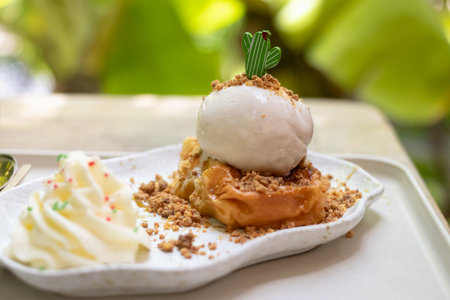 Delicious dessert featuring creamy ice cream on a flaky pastry, garnished with crumbles and mint. Perfect for food lovers.の写真素材