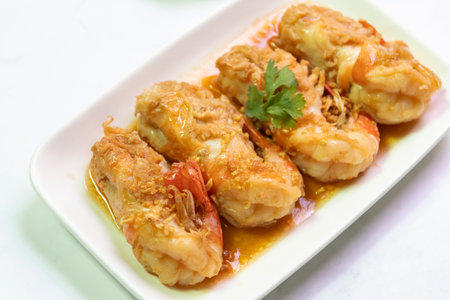 Delicious golden-brown fried prawns served on a white plate, garnished with cilantro, perfect for seafood lovers.の写真素材