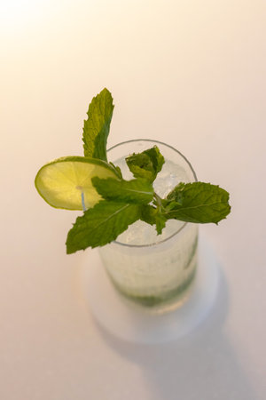 Mojito with soft light in cozy moment, fresh lime juice is added to sugar (or to simple syrup) and mint leaves. The mixture is then gently mashed with a muddler.の写真素材