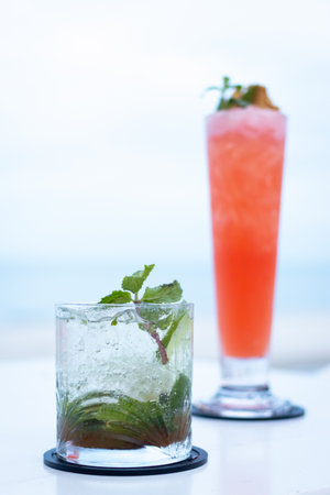 Refreshing cocktails served on a table with a beach view, perfect for summer relaxation and vibrant gatherings.の写真素材