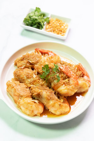 Deliciously cooked shrimp garnished with herbs and served with crunchy toppings, perfect for seafood lovers.の写真素材