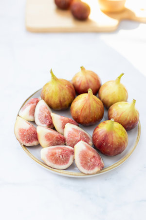 A vibrant plate of fresh figs showcasing their juicy interior and smooth skin, perfect for healthy snacking or culinary creations.の写真素材