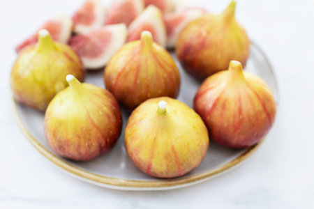 A delightful arrangement of fresh figs on a plate, showcasing vibrant colors and textures, perfect for healthy eating.の写真素材