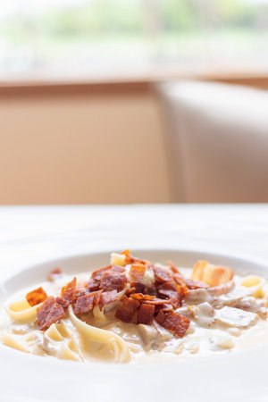 Fettucine carbonara pasta with fried bacon and grated cheese. Carbonara is an Italian pasta dish from Rome made with egg, hard cheese, pancetta and pepper.の写真素材