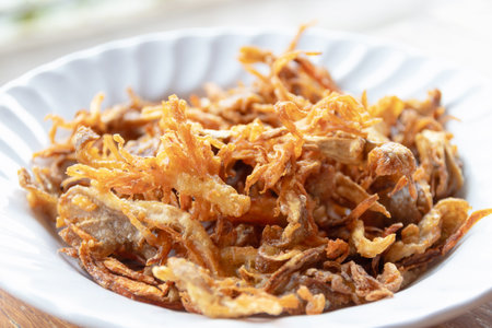A crispy fried mushroom garnish in white bowl, golden brown texture adding savory crunch and warm aroma to dishesの写真素材