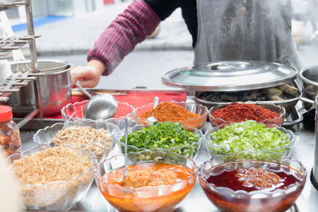 A fresh chopped green onion chili flakes crushed peanut chili oil and spices at street food stall, street food in China.の写真素材