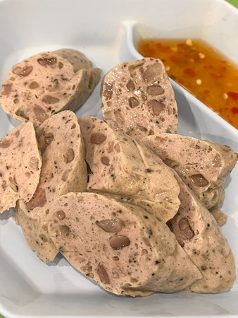 A vietnamese pork sausage slices with dipping sauce, savory texture and herbsの写真素材